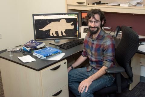 Daniel Cohen smiling at his desk