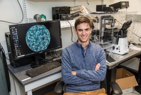 Matthew Heinrich with computer and equipment in lab