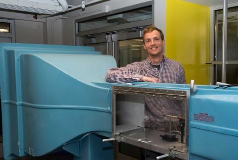 Mark Miller standing with arm resting on blue piece of equipment