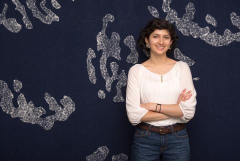 Shalaka Madge smiling in front of dark blue background with white pattern