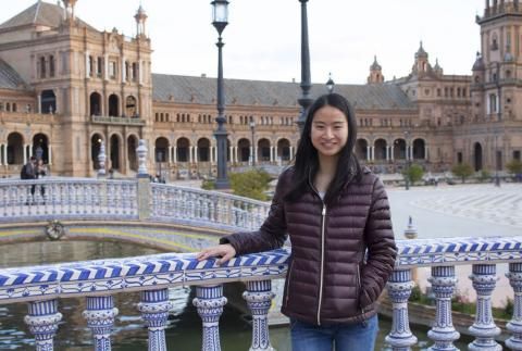 Victoria Ou smiling by ornate blue and white railing