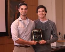 Al Gaillard smiling and holding award with friend