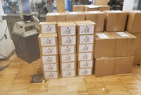 Large stack of cardboard boxes with shipping labels