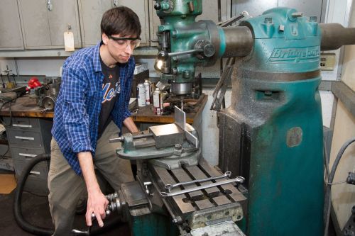 Joshua Umansky-Castro working with a piece of machinery in the shop.