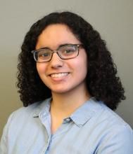 Nina Arcot smiling with gray background