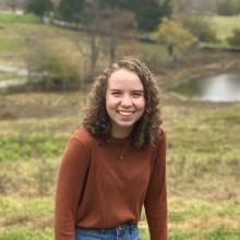 Shannen Prindle smiling with greenery and water in background