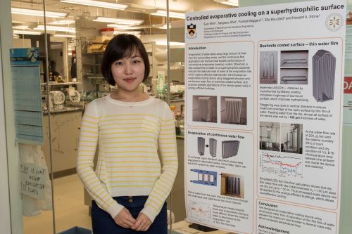 Suin Shim standing in front of an academic poster by a laboratory.