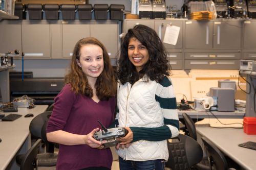 Soumya Sudhakar and Grace Lynch hold remote control