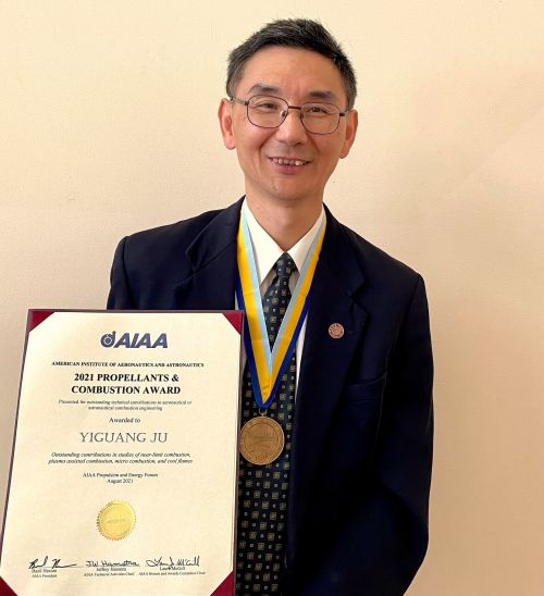 Professor Yiguang Ju holding his 2021 Propellants and Combustion Award and wearing the medal around his neck.