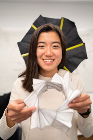 student holding a piece of her project