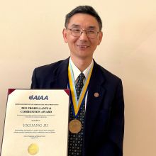 Professor Yiguang Ju holding his 2021 Propellants and Combustion Award and wearing the medal around his neck.